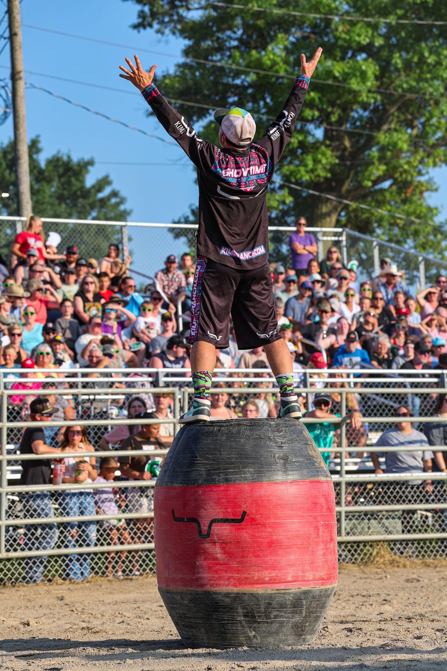 Rodeo barrelman standing on his barrel in front of the crowd